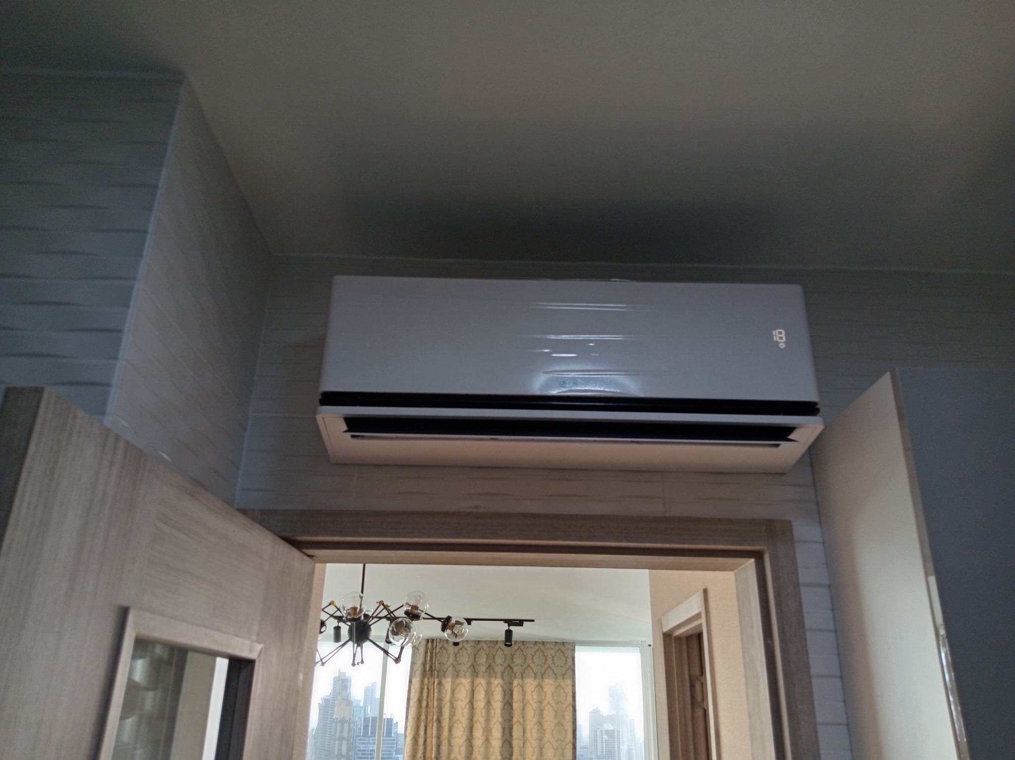 Split residencial inverter instalado sobre puerta